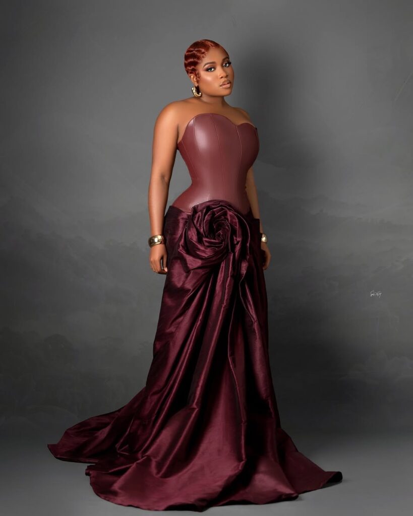 Veekee James in a burgundy leather crop top and draped skirt by M.S.O Lagos. 