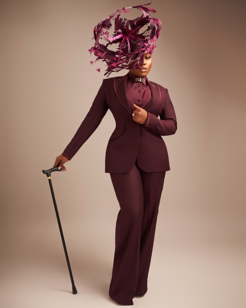 Tailored dark wine-colored suit by Mimmikasu, worn by Veekee James.